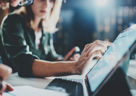 Woman pointing on digital tablet screen at night office .Horizontal.Blurred background.Flares